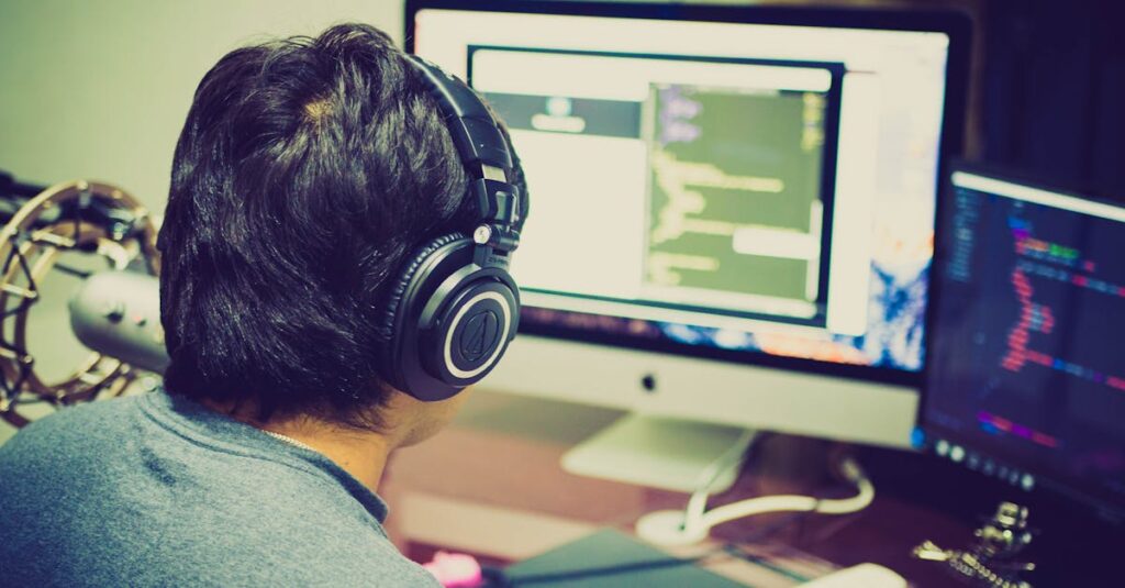 A programmer with headphones focuses on coding at a computer setup with dual monitors.