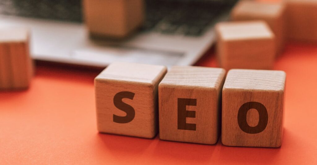 Wooden blocks spelling SEO on a laptop keyboard convey digital marketing concepts.